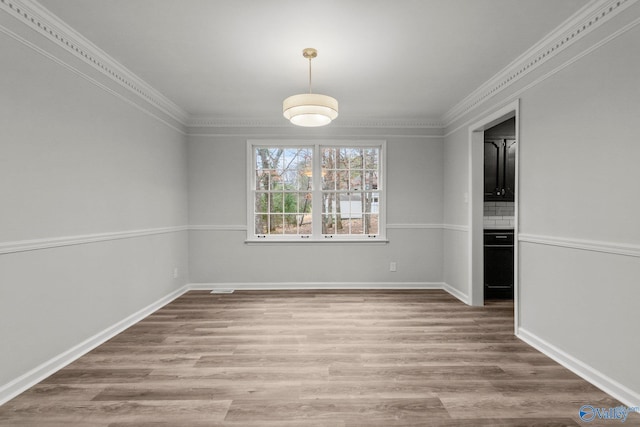 unfurnished dining area with light hardwood / wood-style floors and crown molding