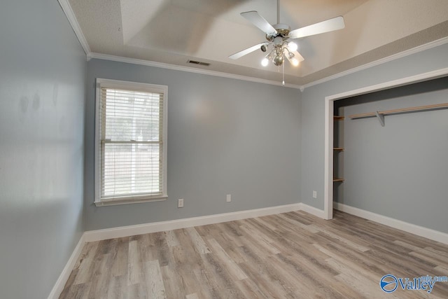 unfurnished bedroom with crown molding, wood finished floors, baseboards, and visible vents