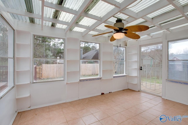 unfurnished sunroom featuring beamed ceiling and a ceiling fan