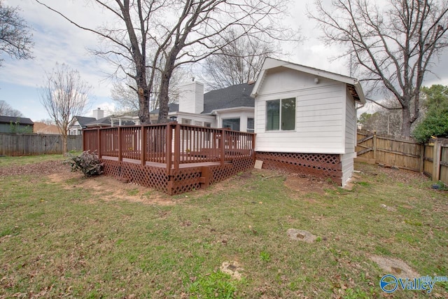 rear view of house featuring a yard, a deck, and a fenced backyard