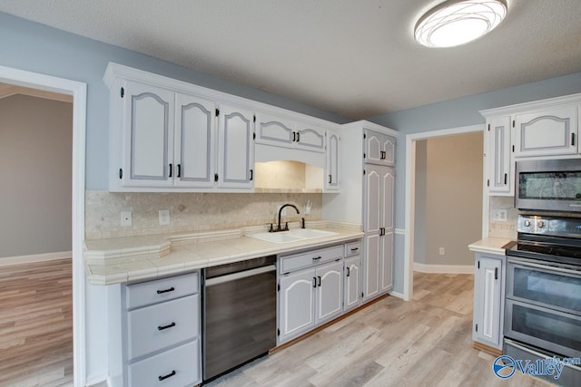 kitchen with a sink, stainless steel appliances, and backsplash