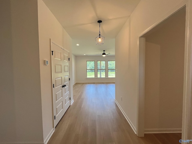 hallway with recessed lighting, wood finished floors, and baseboards