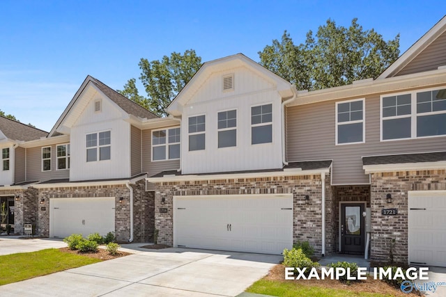 view of property with concrete driveway, board and batten siding, brick siding, and a garage