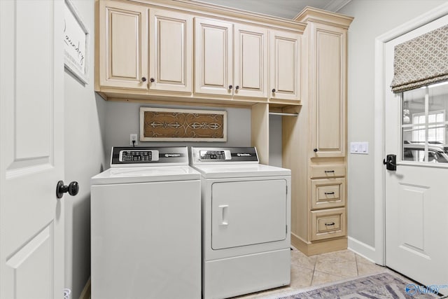 clothes washing area with cabinets, separate washer and dryer, and light tile patterned floors