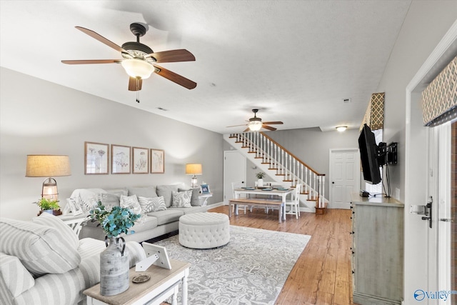 living room with light hardwood / wood-style floors and ceiling fan