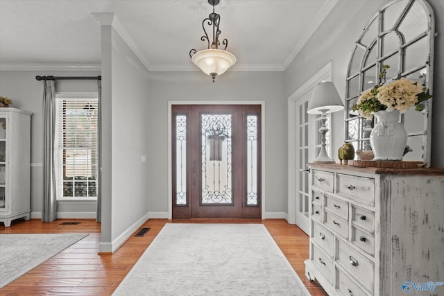 foyer featuring crown molding and light hardwood / wood-style floors