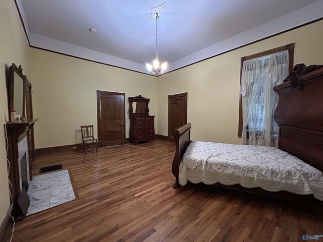 bedroom with hardwood / wood-style floors and a chandelier