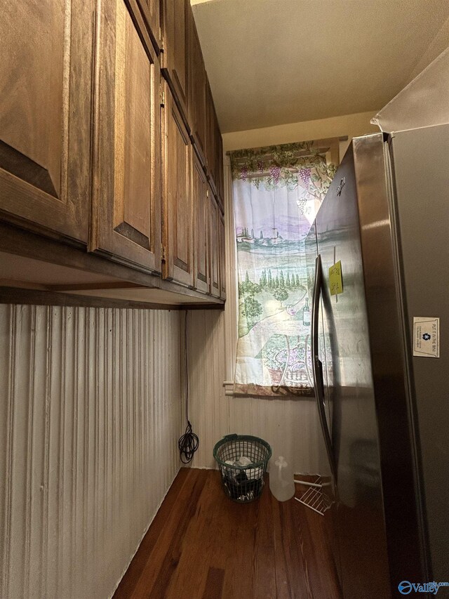 clothes washing area with cabinets and wood-type flooring