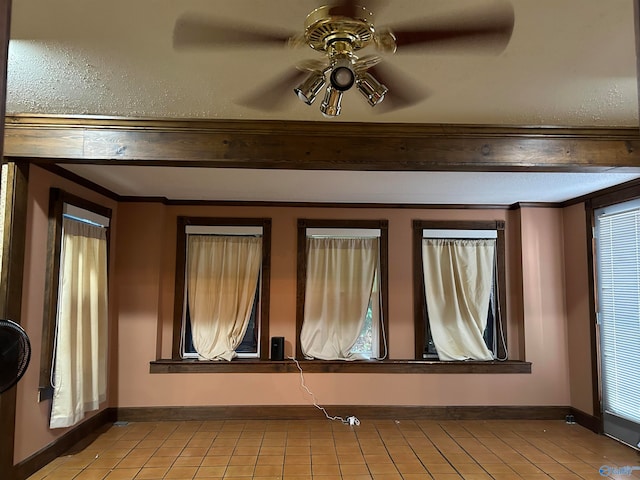 tiled empty room featuring ceiling fan