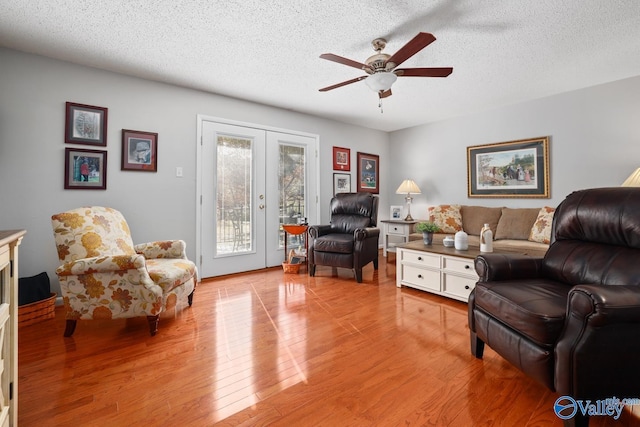 12501 S Shawdee Rd SE, Huntsville, AL 35803 - living area featuring a ceiling fan, light wood finished floors, a textured ceiling, and french doors