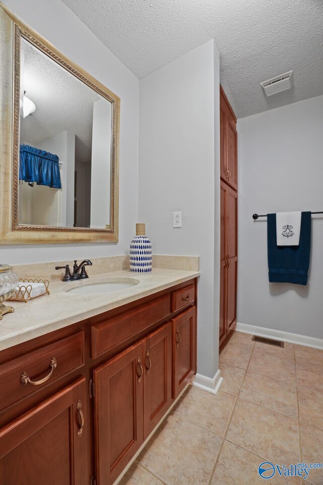 12501 S Shawdee Rd SE, Huntsville, AL 35803 - bathroom featuring a textured ceiling, tile patterned floors, vanity, and baseboards