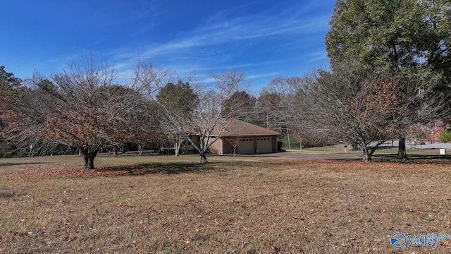 12501 S Shawdee Rd SE, Huntsville, AL 35803 - view of green lawn with driveway and an attached garage