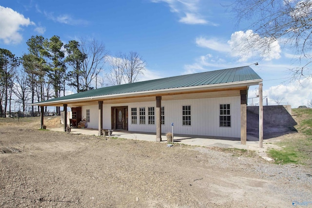 rear view of property featuring a patio and metal roof