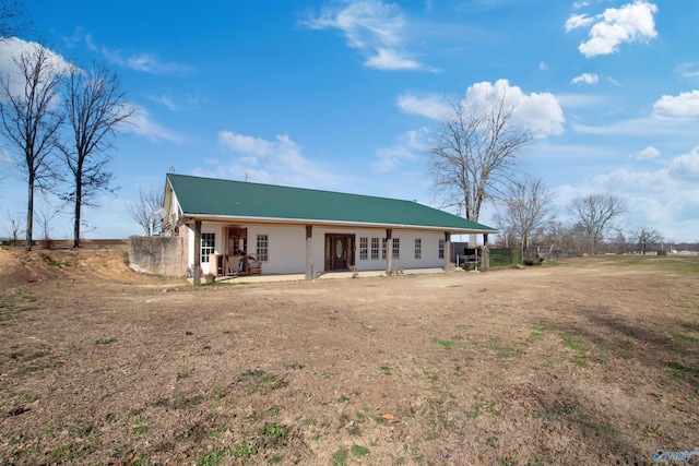 view of front of property with metal roof and a patio