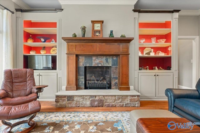 living room featuring crown molding, hardwood / wood-style flooring, and built in features