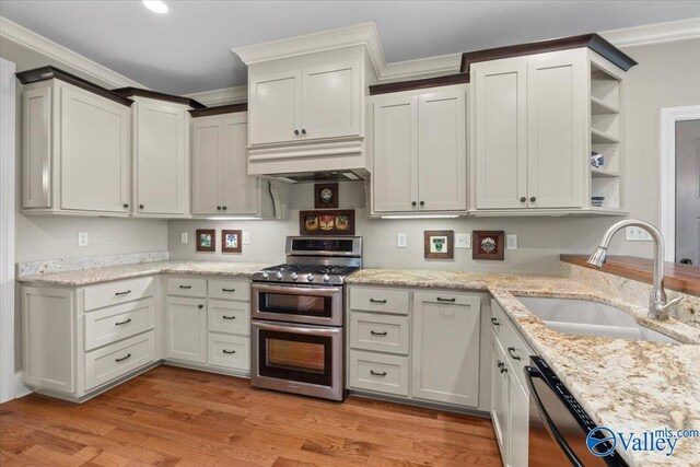 kitchen featuring open shelves, double oven range, black dishwasher, custom exhaust hood, and a sink