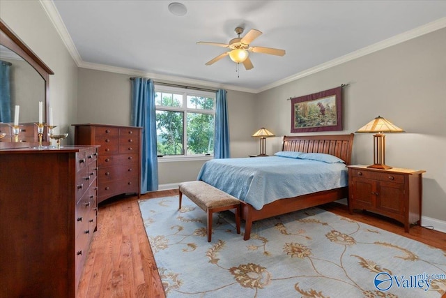 bedroom with light wood-style flooring, baseboards, and ornamental molding