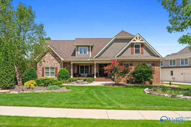 view of front facade featuring roof with shingles, stone siding, and a front lawn