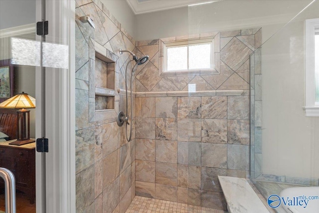 bathroom with ornamental molding and a stall shower