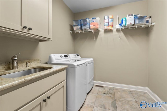 laundry room featuring separate washer and dryer, cabinets, light tile patterned floors, and sink