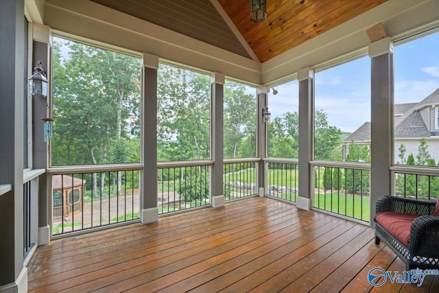 unfurnished sunroom featuring wood ceiling, lofted ceiling, and a wealth of natural light