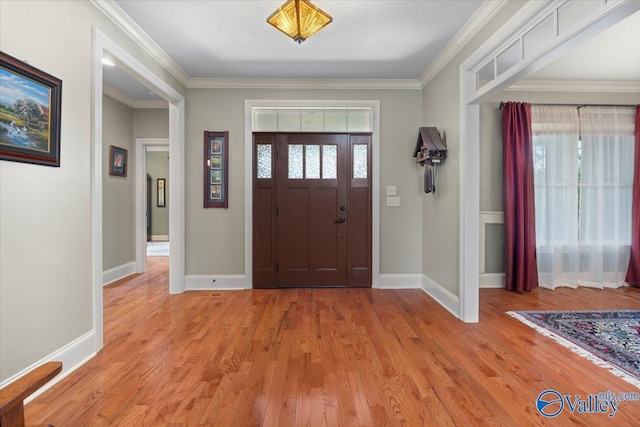 foyer with light wood-type flooring, baseboards, and ornamental molding