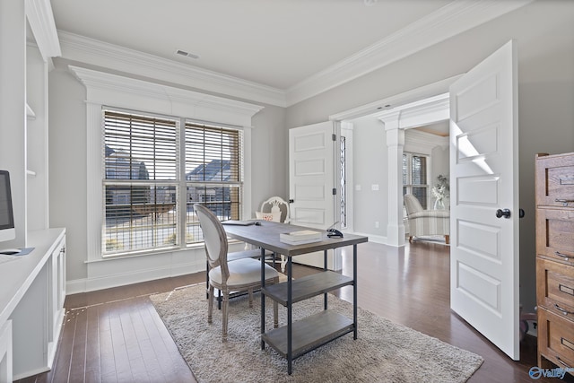 dining room with crown molding, dark wood-type flooring, and decorative columns