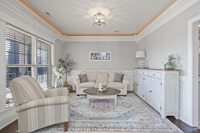 living room with ornamental molding, hardwood / wood-style floors, and a notable chandelier