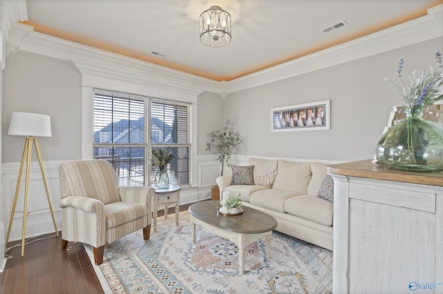 living room featuring a notable chandelier, crown molding, and dark hardwood / wood-style floors