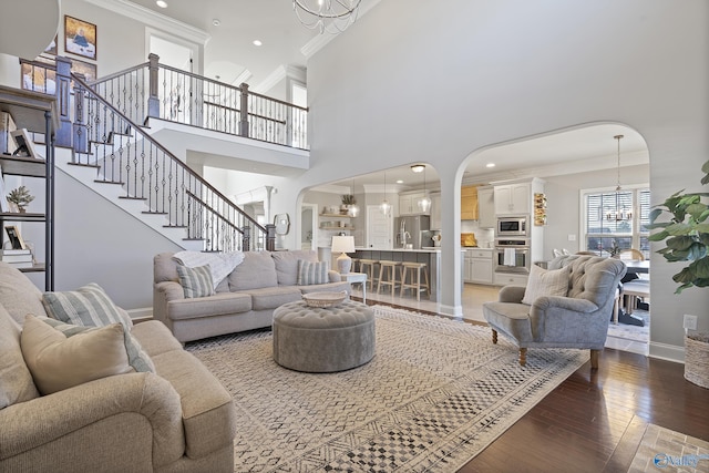 living room with hardwood / wood-style flooring, crown molding, and a notable chandelier