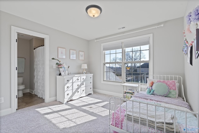 bedroom with ensuite bath and light colored carpet