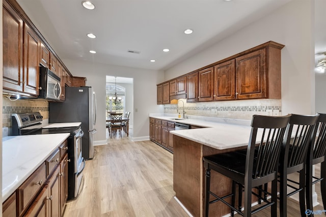 25 County Road 504, Centre, AL 35960 - kitchen with stainless steel appliances, a peninsula, a kitchen breakfast bar, a sink, and backsplash