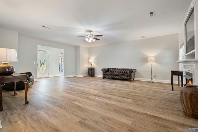25 County Road 504, Centre, AL 35960 - interior space with a warm lit fireplace, light wood-type flooring, ceiling fan, baseboards, and visible vents