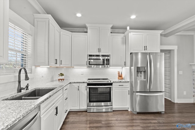 kitchen featuring appliances with stainless steel finishes, a sink, and white cabinetry