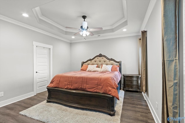 bedroom with dark wood-style flooring, a raised ceiling, and baseboards