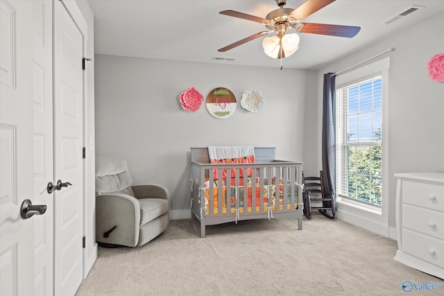 bedroom featuring light carpet, baseboards, visible vents, and a ceiling fan