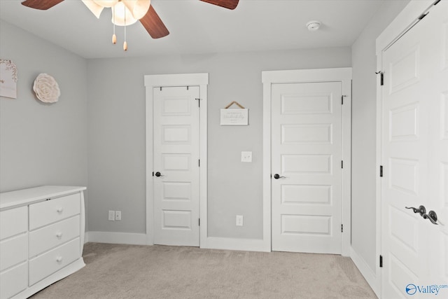 unfurnished bedroom featuring a ceiling fan, light colored carpet, and baseboards