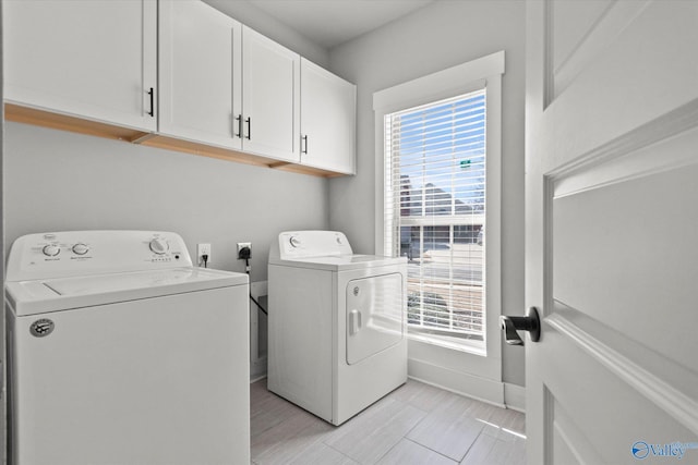 laundry room featuring washer and clothes dryer, cabinet space, and baseboards