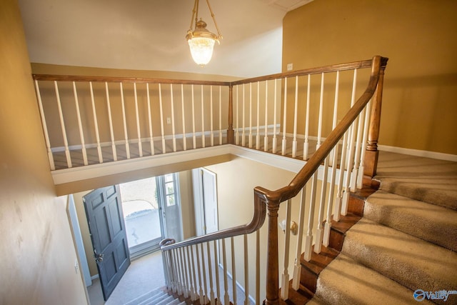 staircase with carpet and a towering ceiling