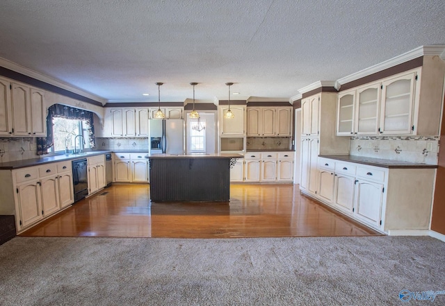 kitchen featuring pendant lighting, crown molding, stainless steel appliances, and a kitchen island