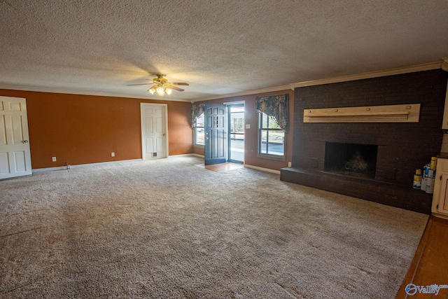 unfurnished living room with ornamental molding, carpet, ceiling fan, a brick fireplace, and a textured ceiling