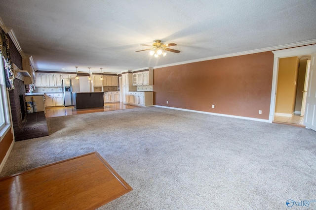 unfurnished living room with crown molding, carpet floors, a textured ceiling, and ceiling fan