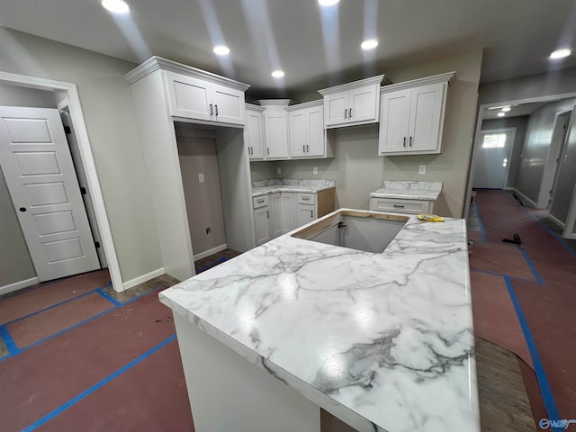 kitchen featuring light stone countertops, white cabinetry, and a center island