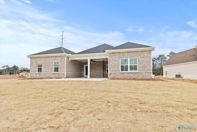 view of front facade featuring a patio area, central air condition unit, and a front lawn