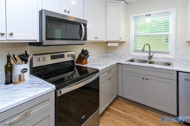 1409 8th Ave SE, Decatur, AL 35601 - kitchen with appliances with stainless steel finishes, a sink, gray cabinets, light stone countertops, and light wood-style floors