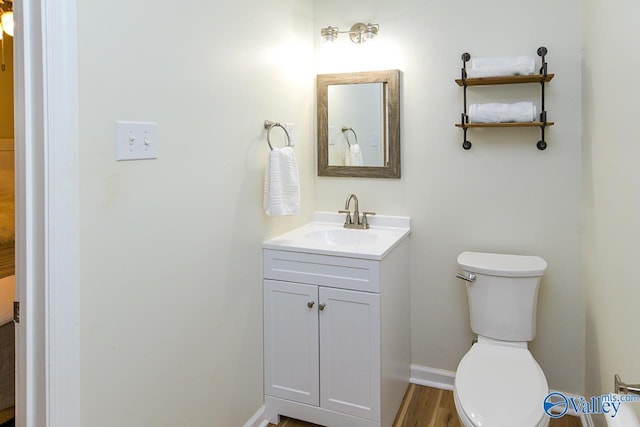 1409 8th Ave SE, Decatur, AL 35601 - half bath featuring vanity, toilet, baseboards, and wood finished floors