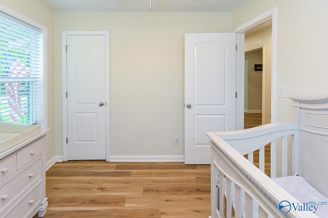 1409 8th Ave SE, Decatur, AL 35601 - bedroom with light wood finished floors, multiple windows, and baseboards
