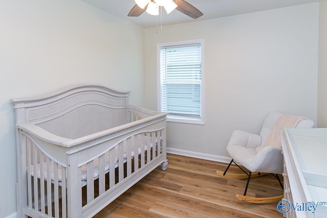 1409 8th Ave SE, Decatur, AL 35601 - bedroom with baseboards, wood finished floors, a crib, and a ceiling fan