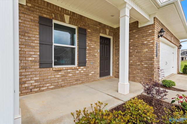 18577 Cottontail Ln, Athens, AL 35613 - view of exterior entry with brick siding, a garage, and covered porch