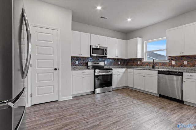 18577 Cottontail Ln, Athens, AL 35613 - kitchen featuring light wood-style floors, appliances with stainless steel finishes, a sink, and tasteful backsplash